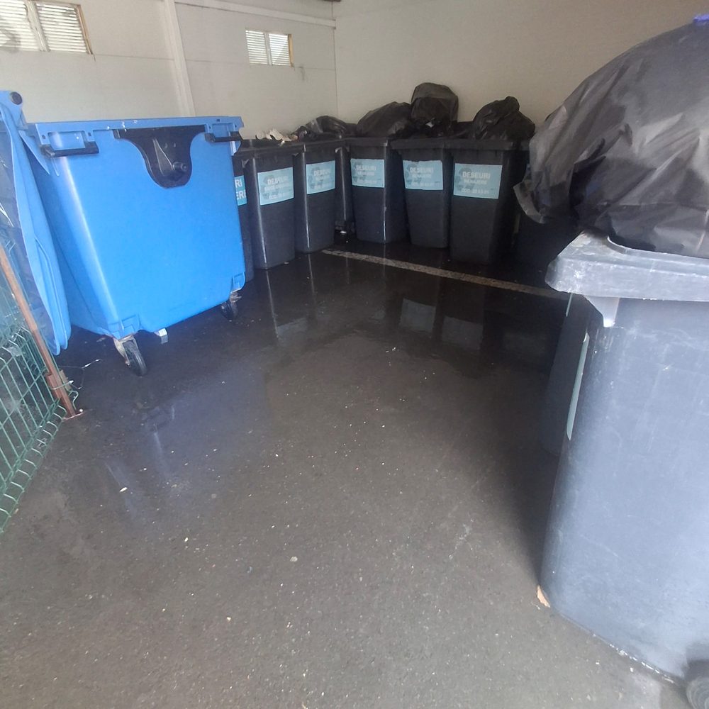 Zonă de colectare selectivă a deșeurilor, cu pubele curățate și pardoseala igienizată