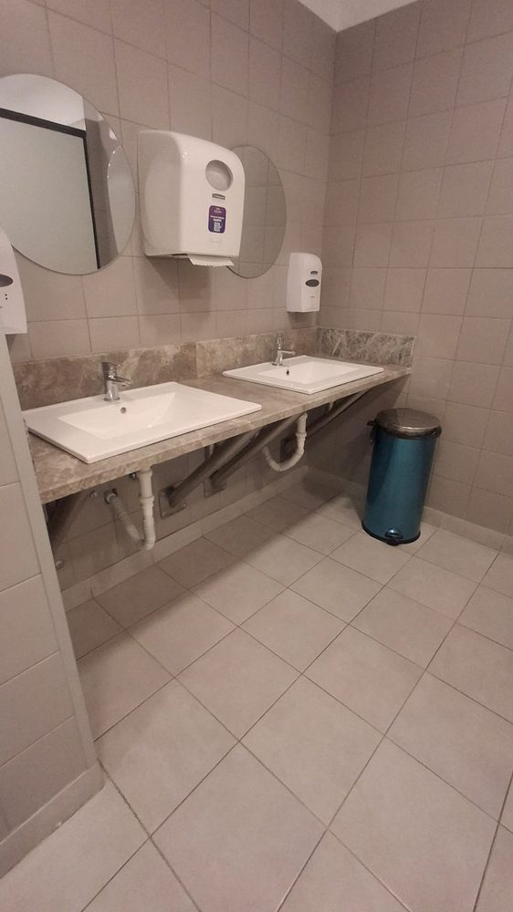 Zonă de lavoare cu dispensere de săpun și prosoape, curățată și aprovizionată