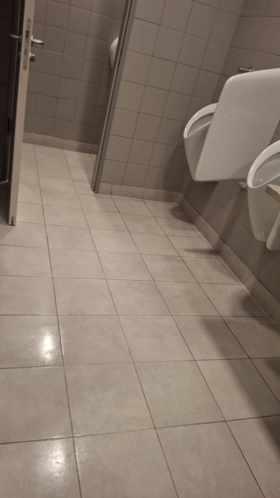 Hol de acces între cabinele unui grup sanitar, cu gresia curățată