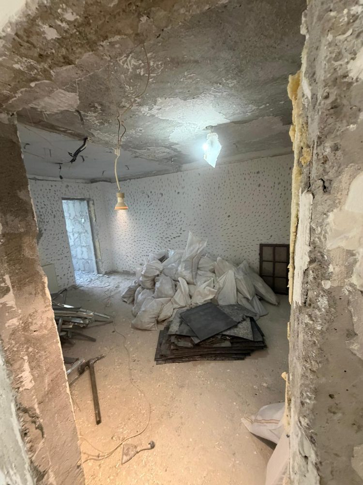 Încăpere cu moloz și folii de protecție rămase după lucrările de construcție