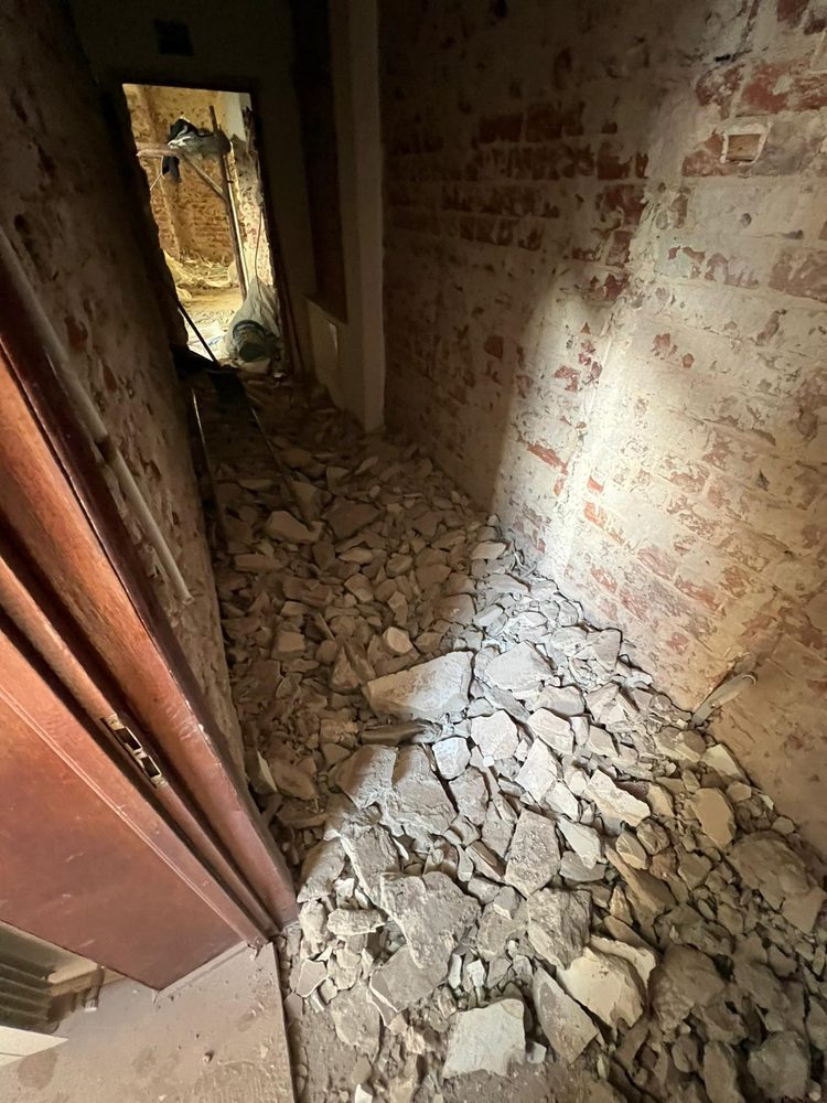 Moloz și reziduuri de construcție acumulate pe o casă a scării, înainte de curățare