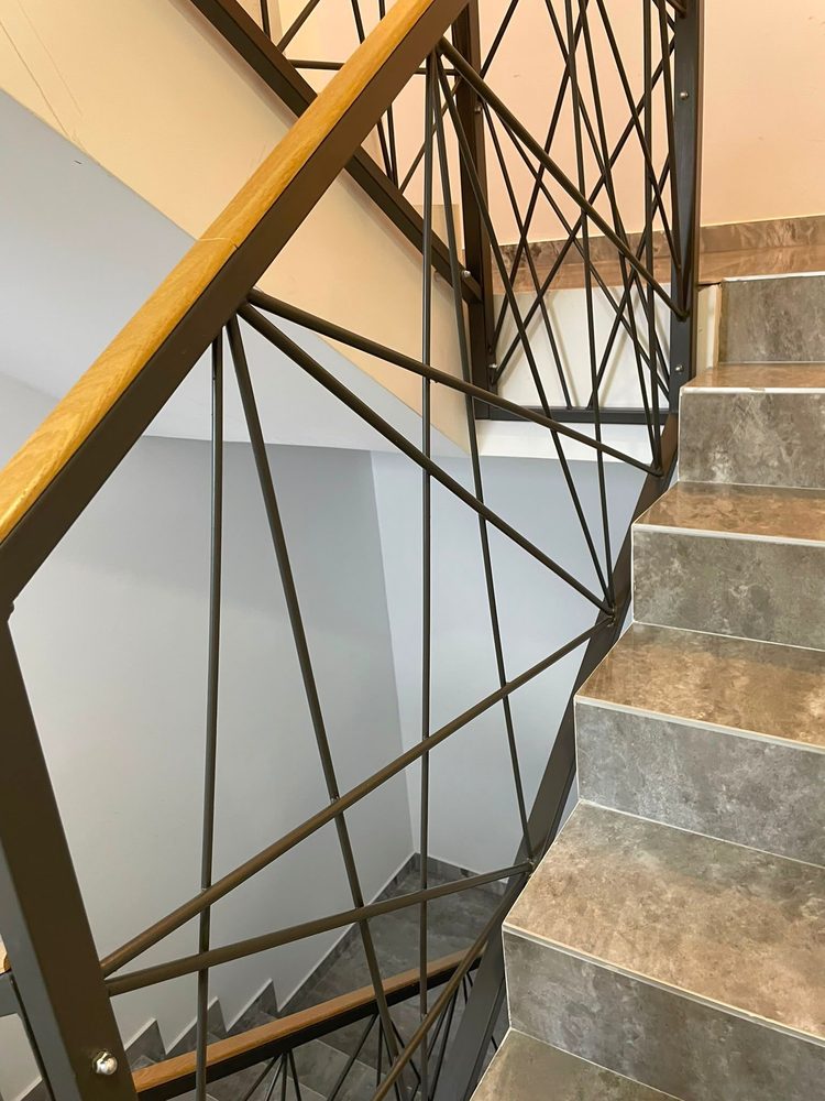 Scară interioară cu balustradă din metal și lemn, curățată pe fiecare material