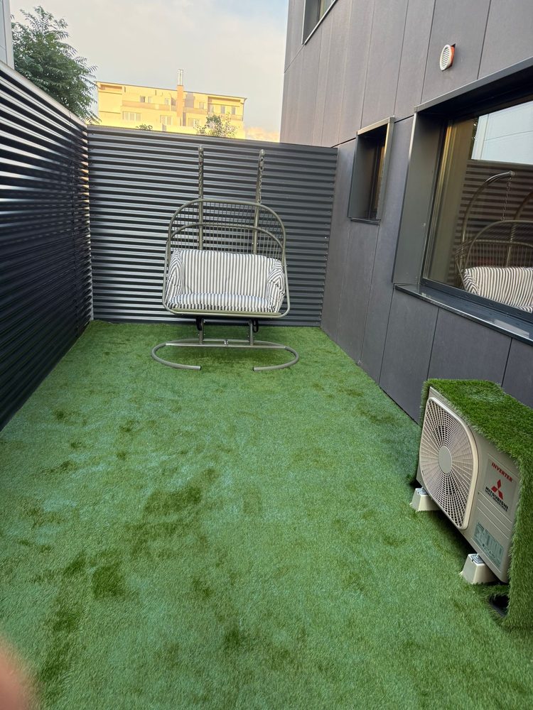 Spațiu exterior cu gazon artificial și mobilier de grădină, după întreținere